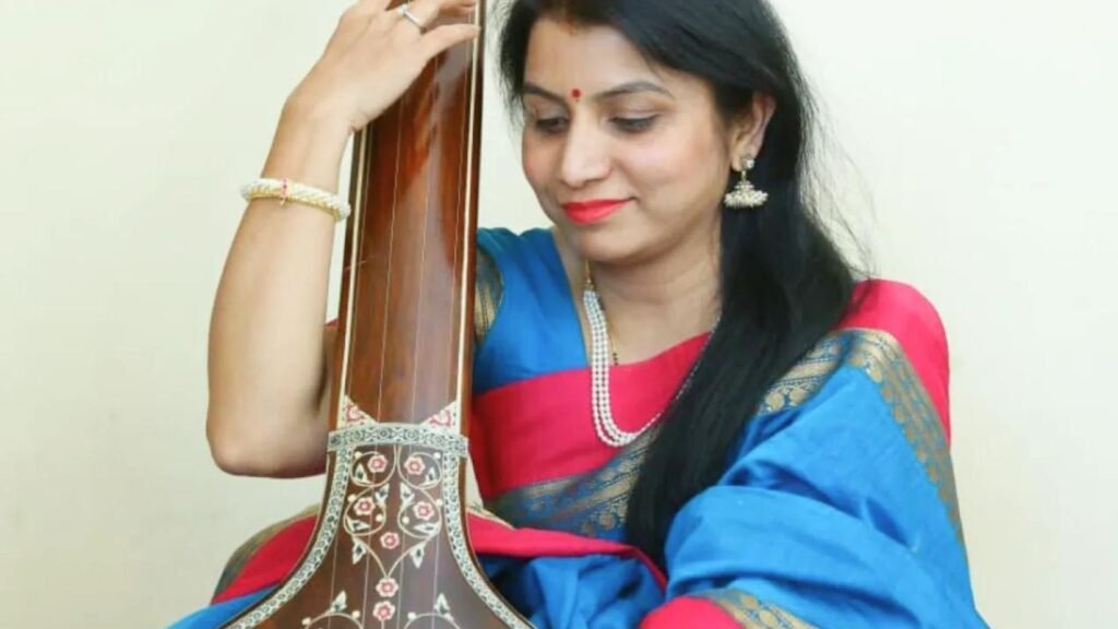 a lady holding a guitar as she plays Indian Classical Music 