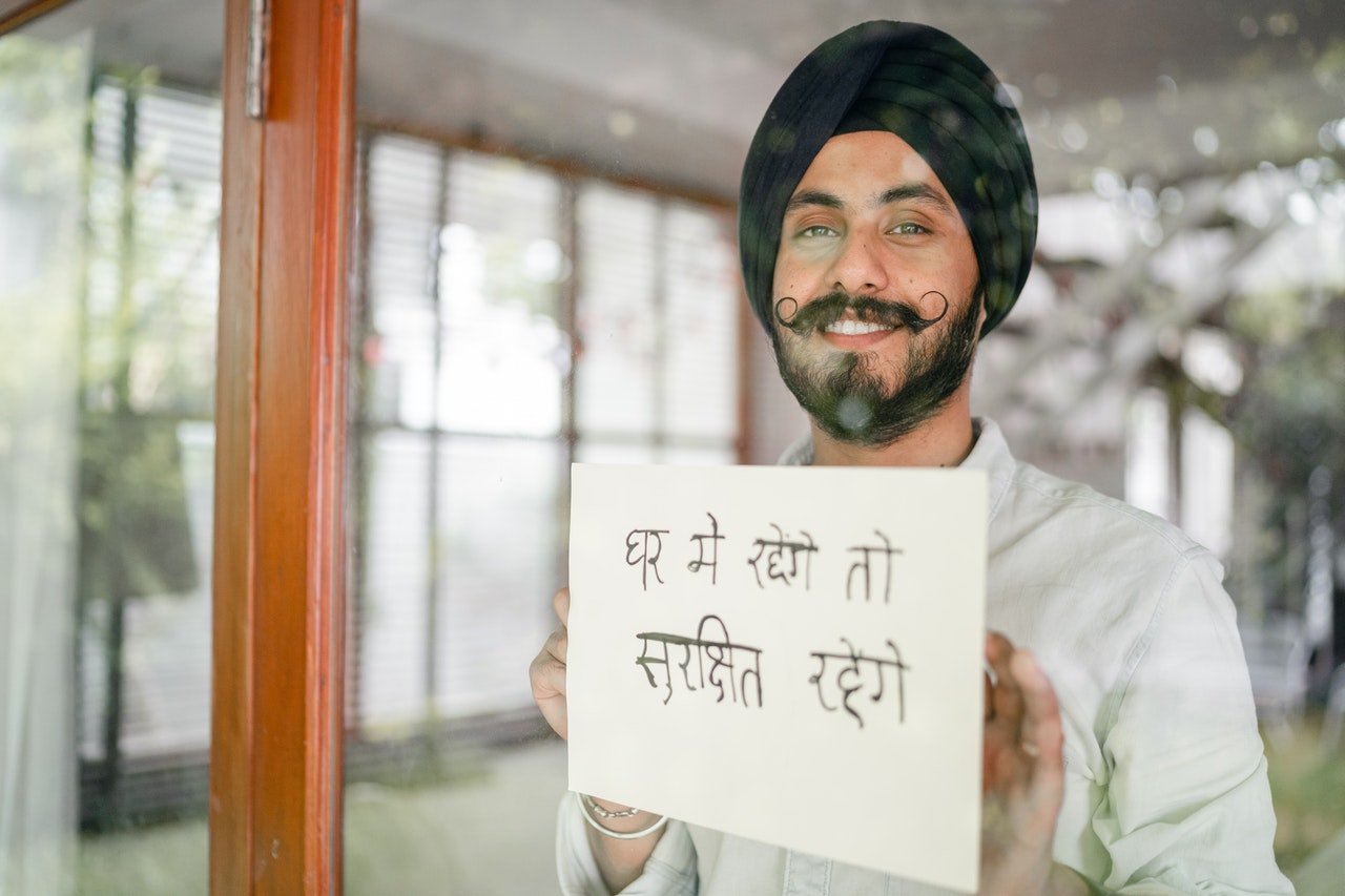 a man holding a paper with Indian language showing the concept of how to speak Indian languages fluently